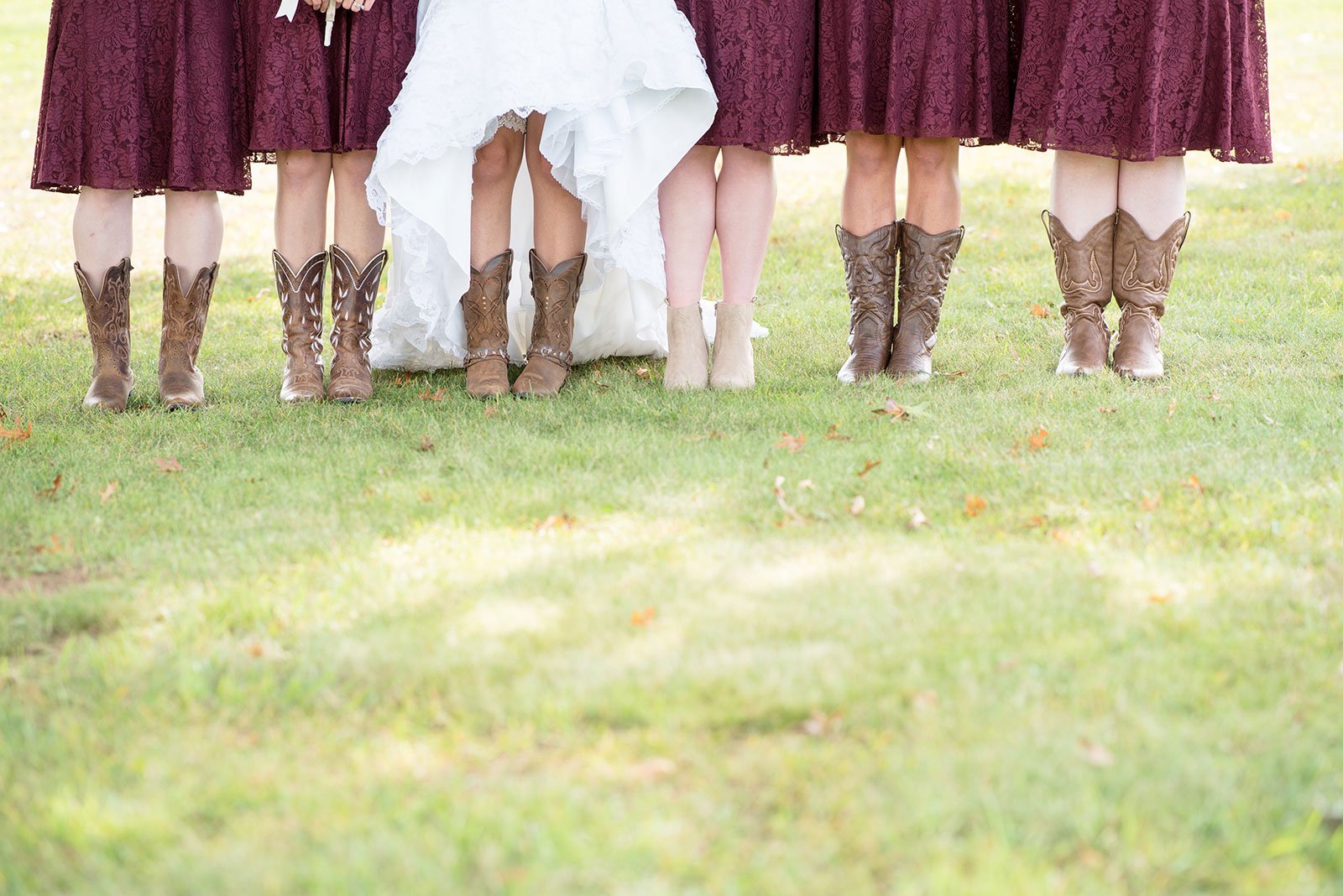 Line of bridesmaids and bride showing matching cowboy boots