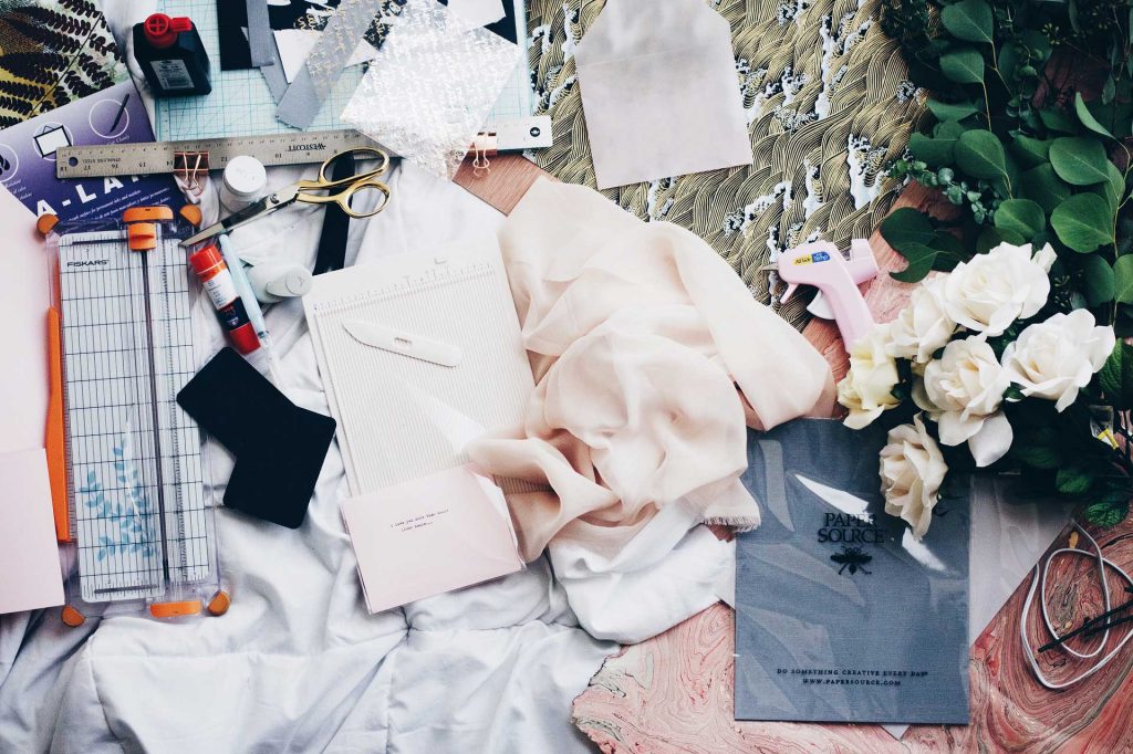 Messy Fashion design workspace with flowers and pink material