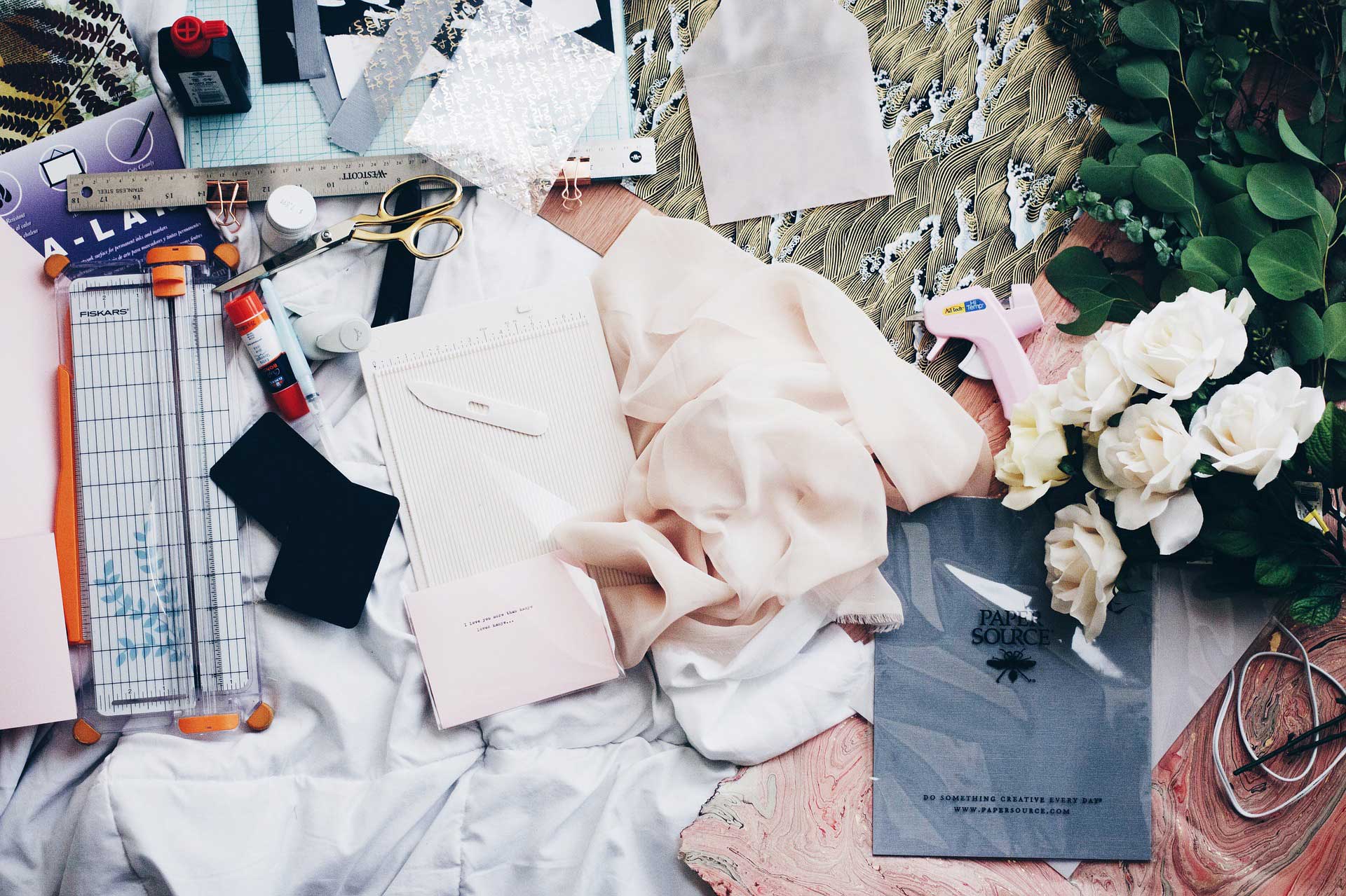 Messy Fashion design workspace with flowers and pink material
