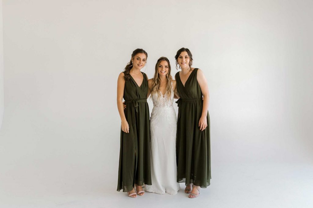 Two brunette girl in chiffon bridesmaid dress with blond bride