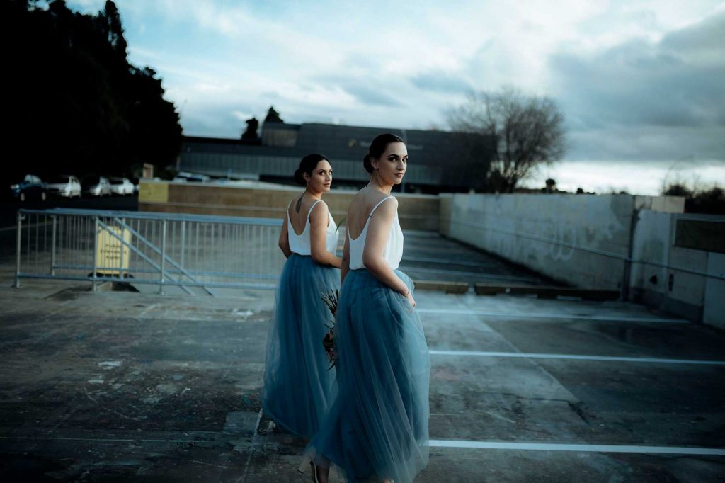 two girls in blue tutu skirt looking back