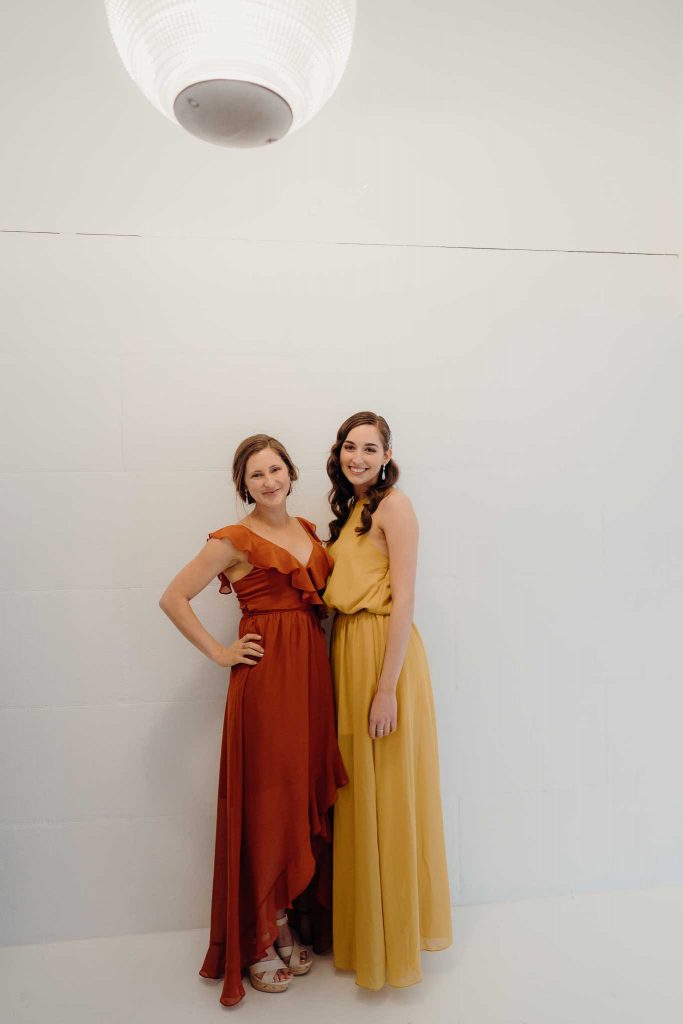Duo under a lamp wearing Gemma and Ivy dresses
